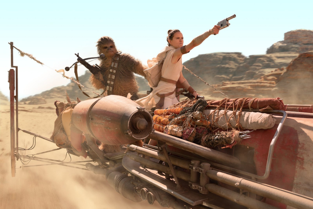 Rey y Chewbacca en una nave speeder en una escena en el desierto
