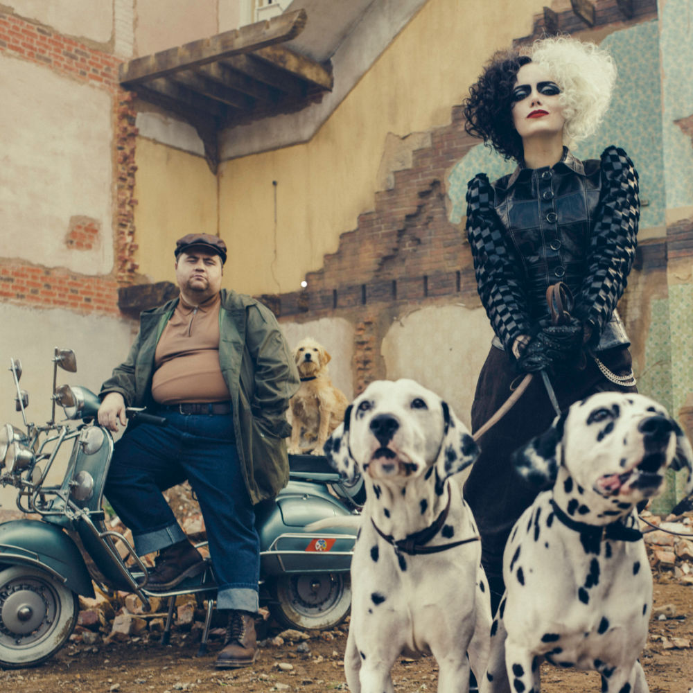 Emma Stone en su personaje de Cruella con dos perros dálmatas