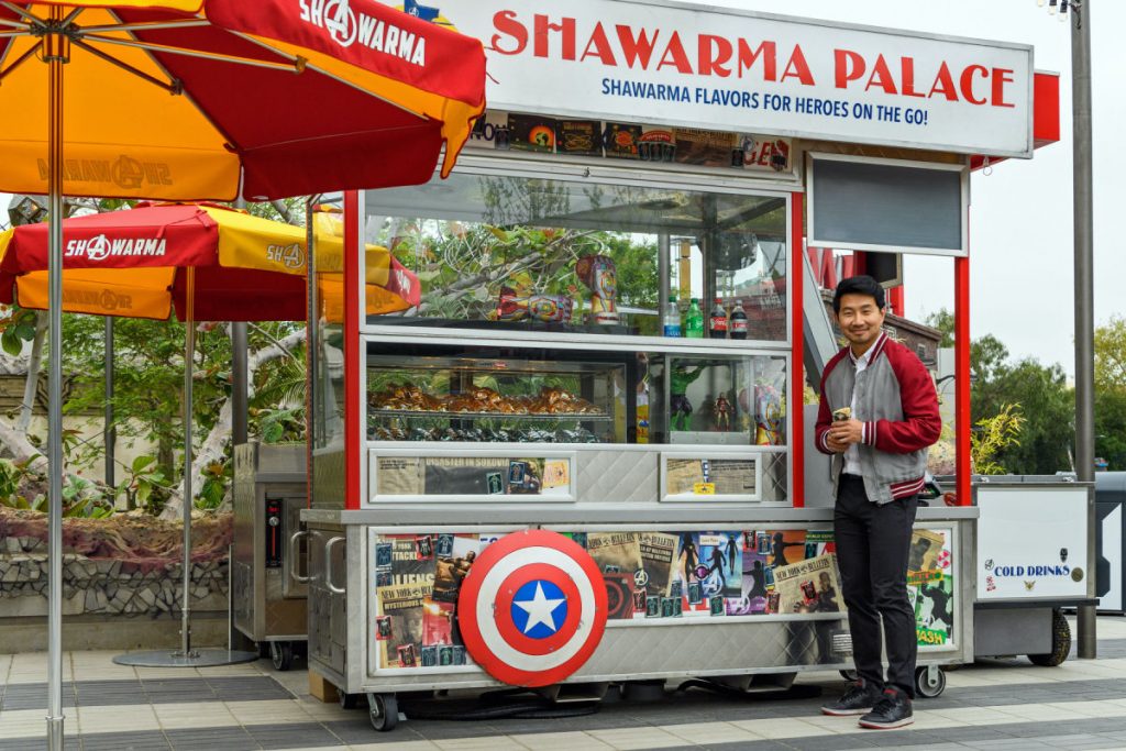 Simu Liu enfrente de Shawarma Palace en Avengers Campus