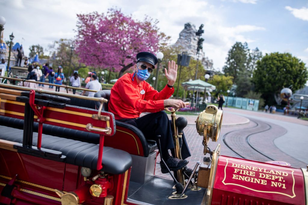 Un coche rojo de Disneylandia con su chofer.