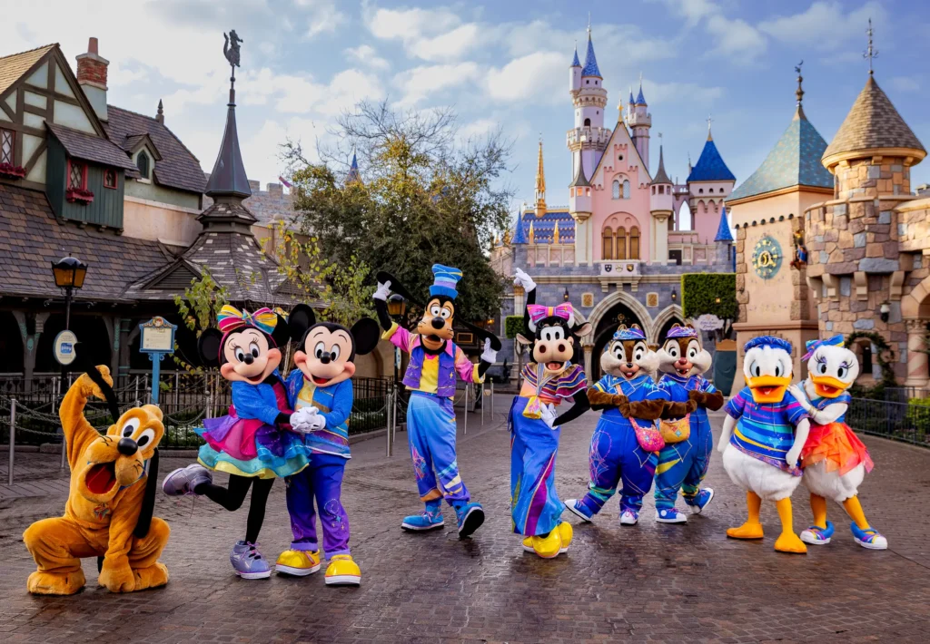 Pluto, Mickey, Minnie, Tribilín, Clarabel, Chip y Dale, Pato Donald y Daisy vistiendo sus trajes nuevos del aniversario 70 de Disneylandia en la explanada de Fantasyland, detrás del Castillo.